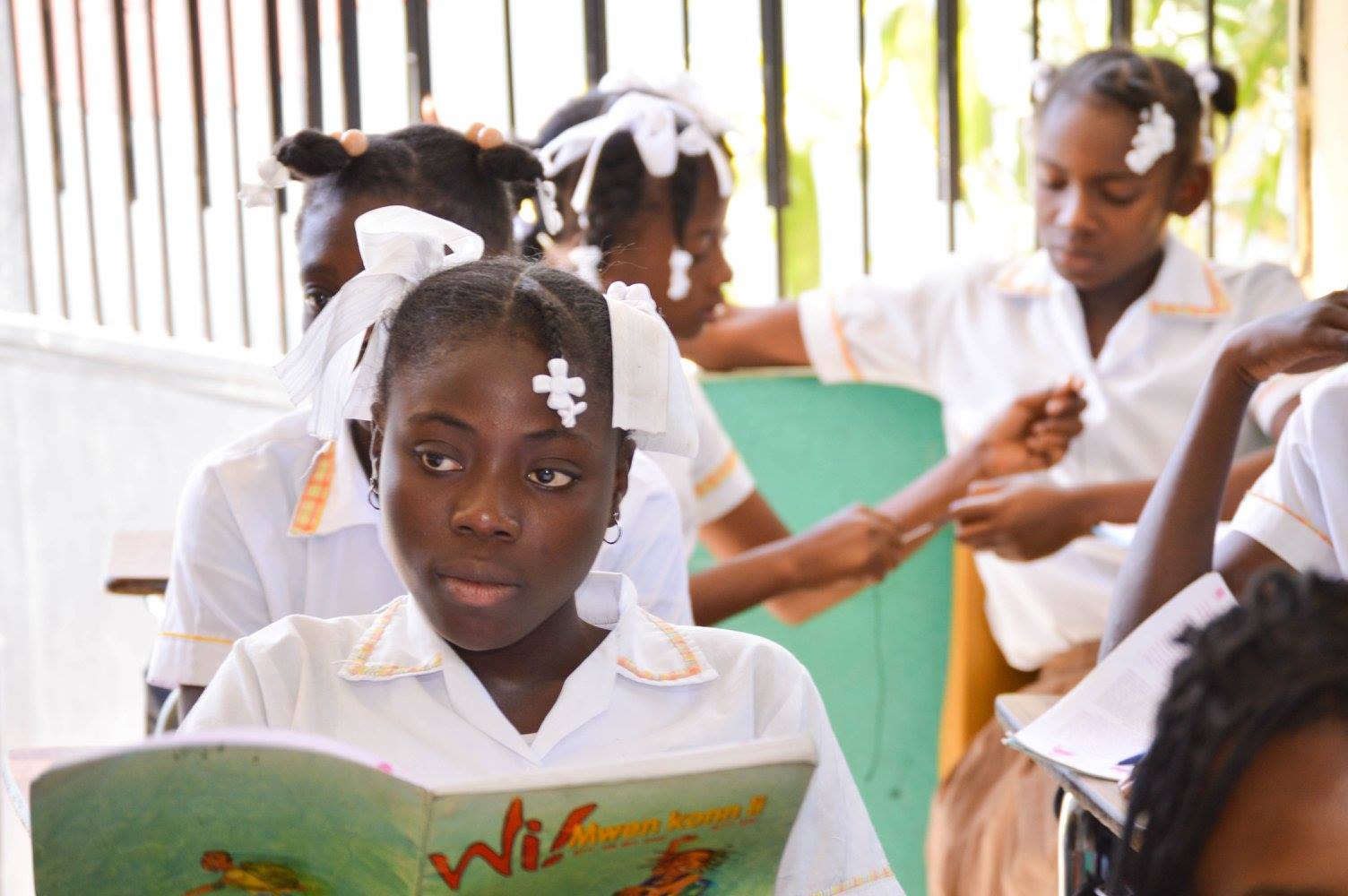 A Haitian girl in her classroom reading